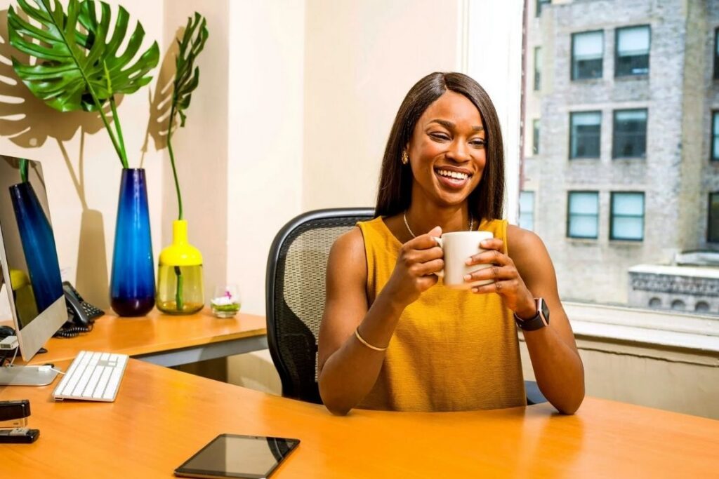 Mulher feliz na empresa, simbolizando o recebimento do quinquênio