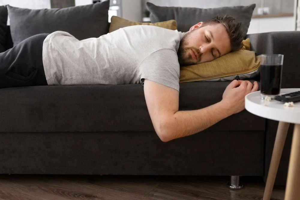 Sedentarismo: homem branco deitado no sofá 
