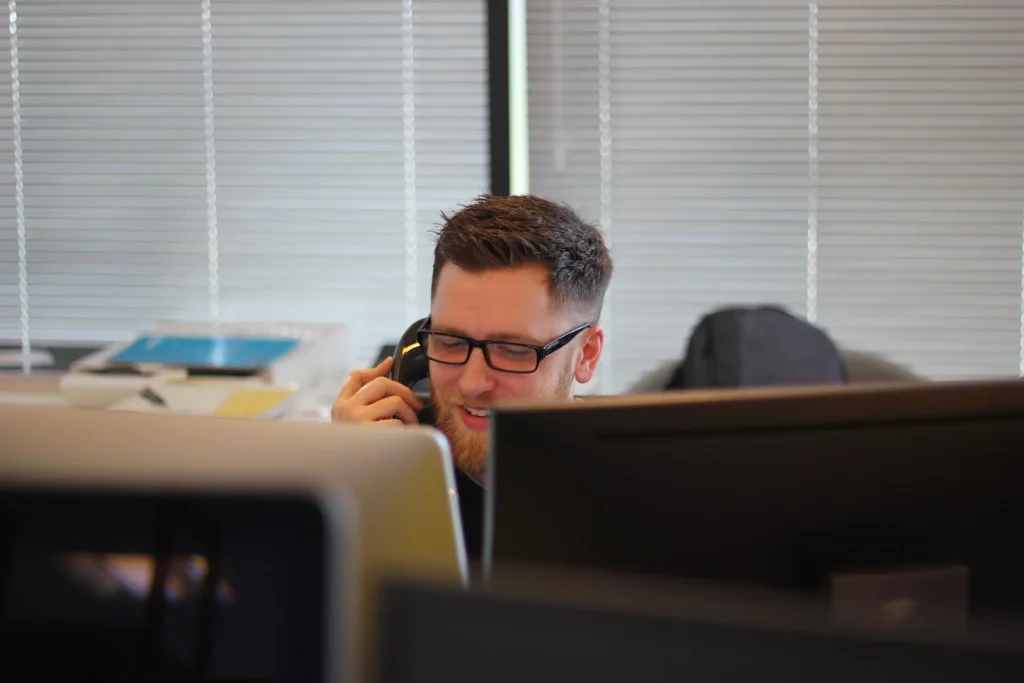 ergonomia no trabalho: homem branco atendendo ao telefone no escritório