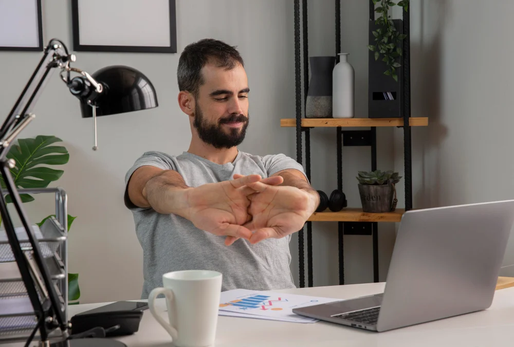 Risco ergonômico: homem esticando os braços enquanto trabalha em casa