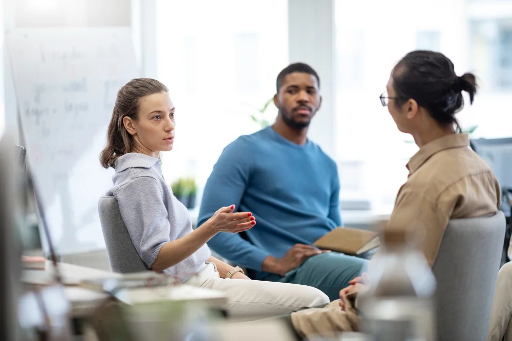 psicologia organizacional: três colaboradores interagindo no ambiente de trabalho