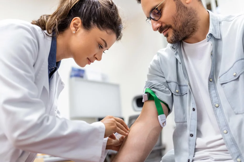 Dia do Combate ao Colesterol: enfermeira tirando sangue de um homem