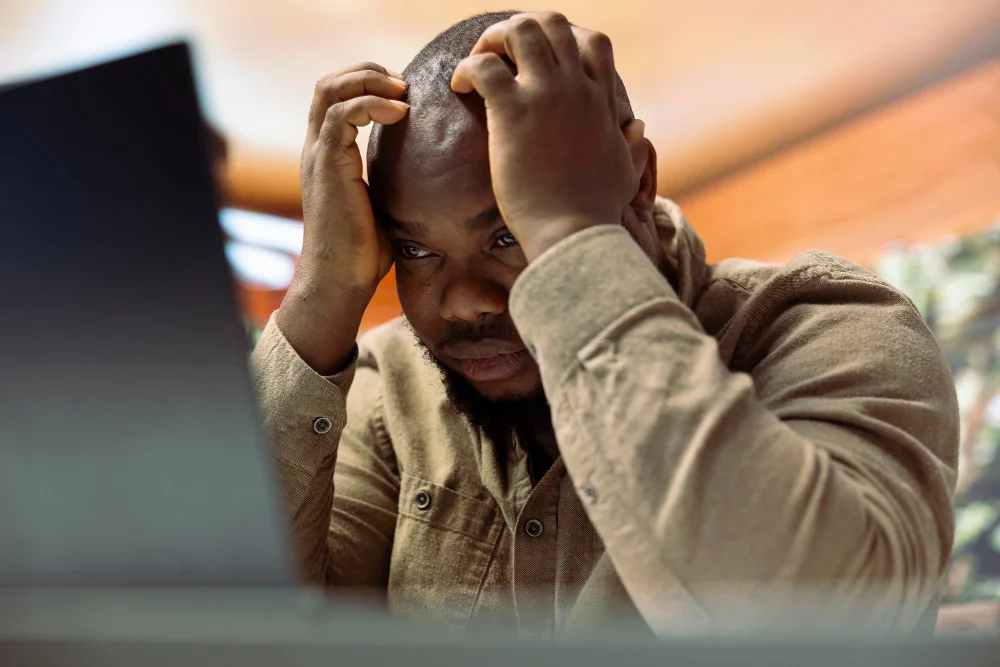 Imagem fotográfica que mostra homem passando por burnout no trabalho